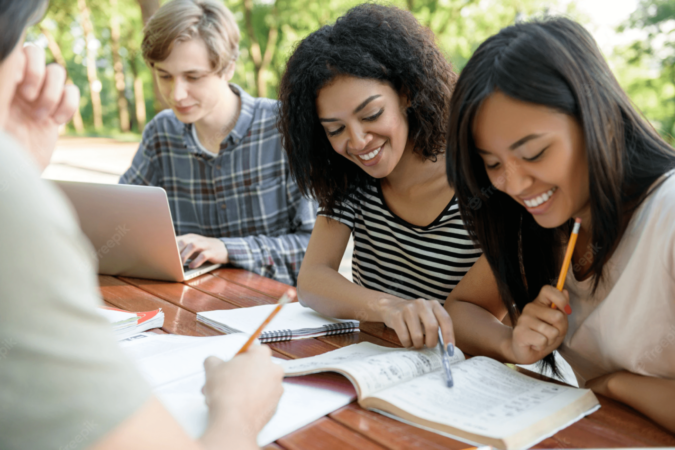 alunos-felizes-sentados-e-estudando-ao-ar-livre-enquanto-fala_171337-13401 (1)