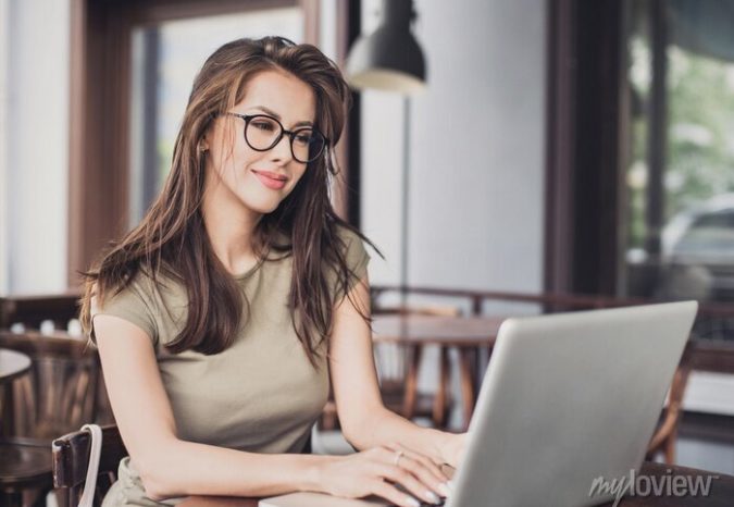 mulher-feliz-usando-o-laptop-no-cafe-jovem-linda-sentada-em-uma-cafeteria-e-trabalhando-no-computador-700-99715801 racunho